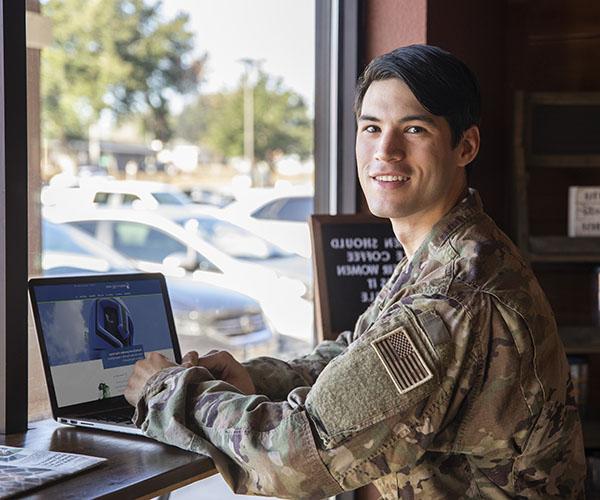 military student working on a laptop