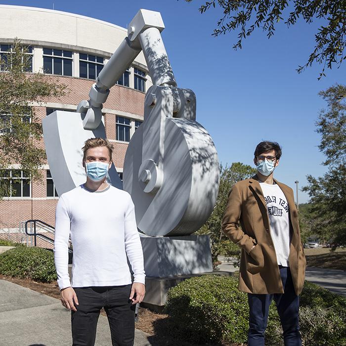 two uwf computer science students standing in front of building 4